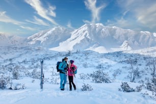 Ein Skitourenpaar macht eine Pause auf dem Gipfel des Berges in der Niederen Tatra in der Slowakei.