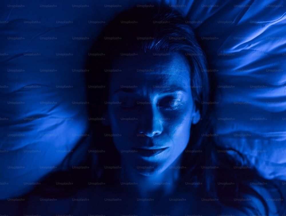 Um close-up de mulher dormindo na cama à noite.