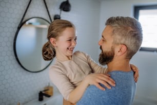 A father having fun with his little daughter in bathroom.