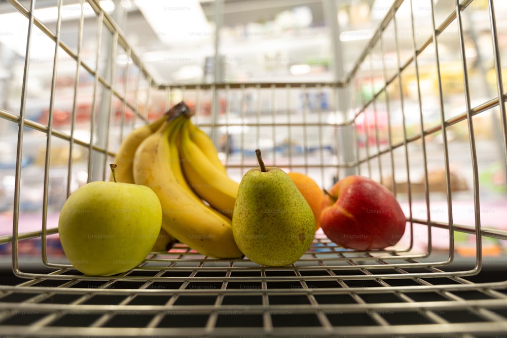 Früchte innen in einem Einkaufswagen im Supermarkt, Inflationskonzept.
