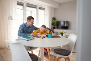 A father with his little daughter with Down syndrome learning at home.