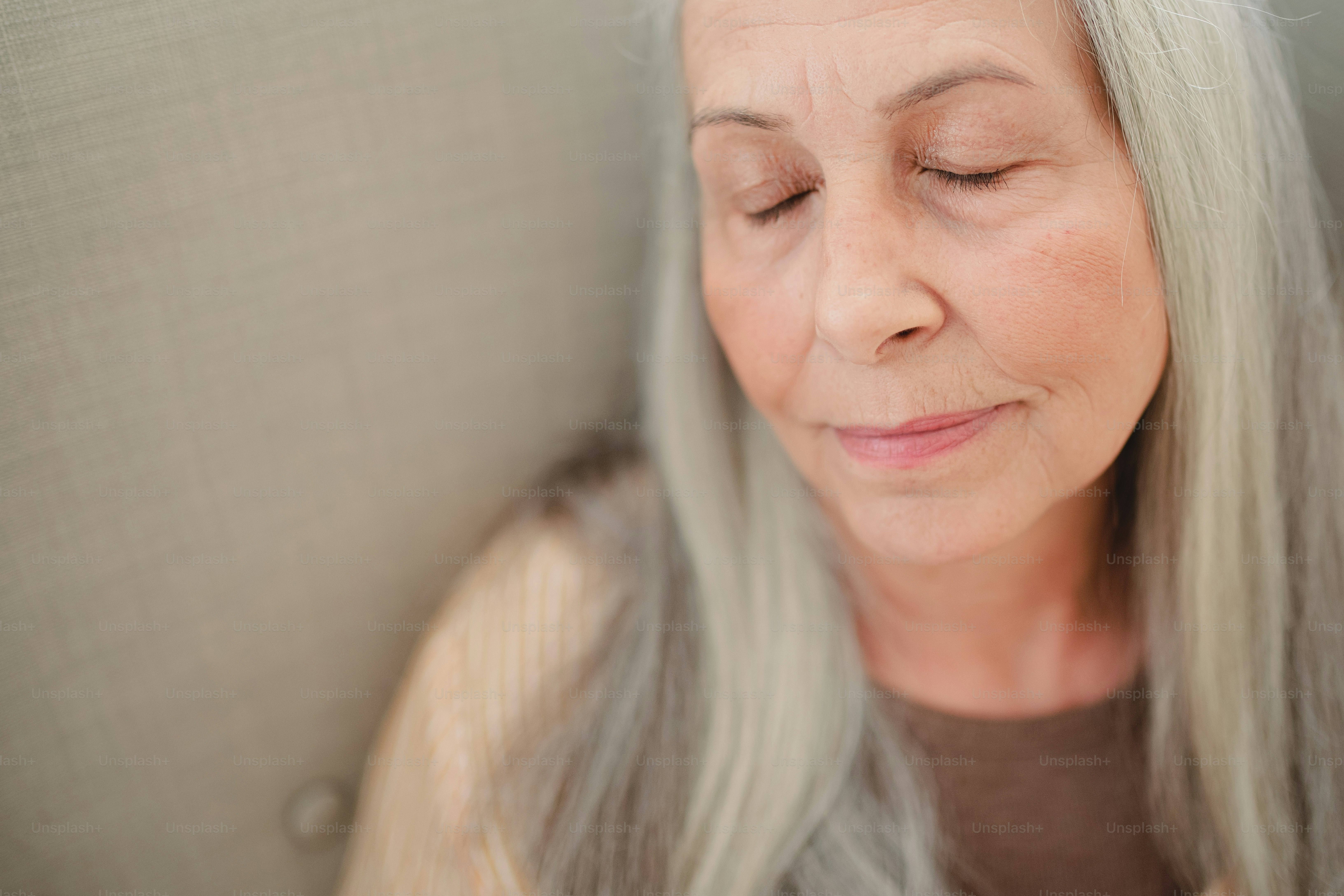 A close up of senior woman with her eyes closed.