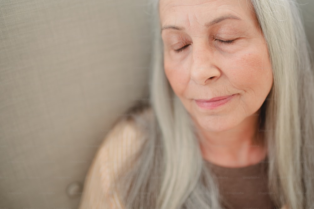 A close up of senior woman with her eyes closed.