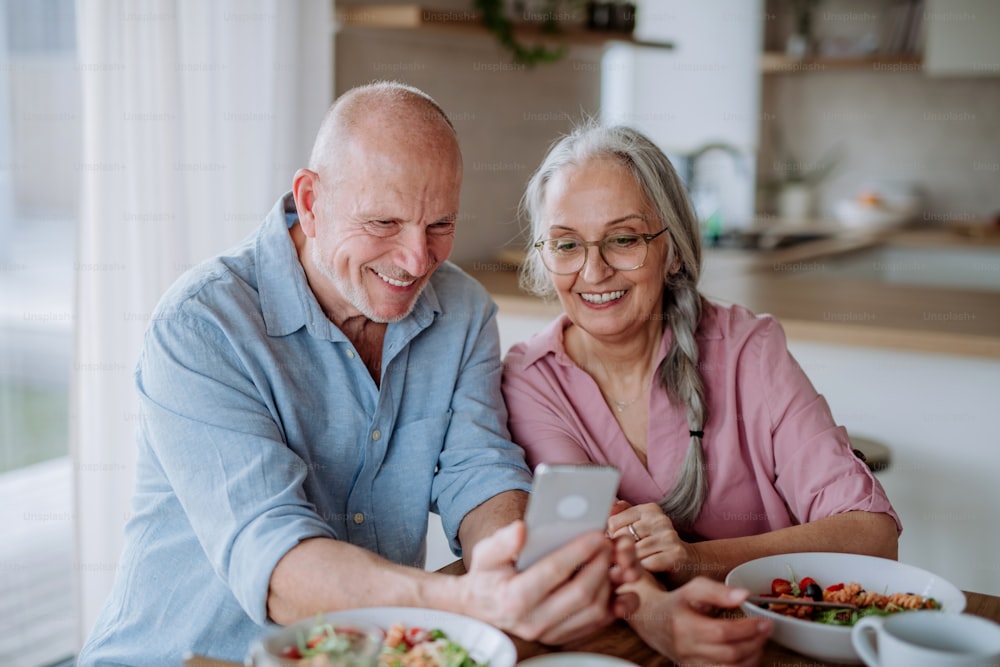 Una feliz pareja de ancianos cenando juntos en casa.