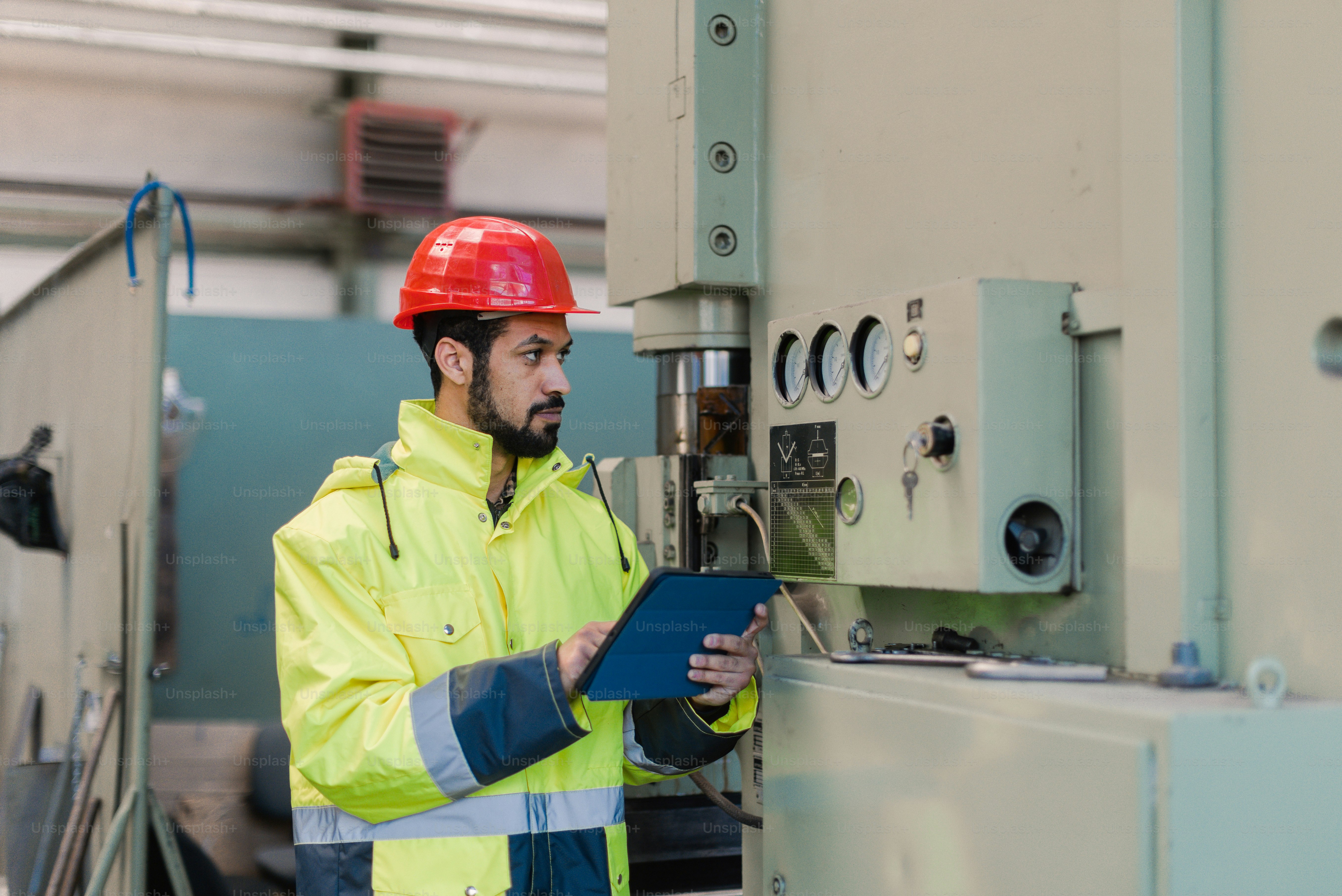 Maintenance or engineering professional working with industrial equipment and controls in an active manufacturing plant