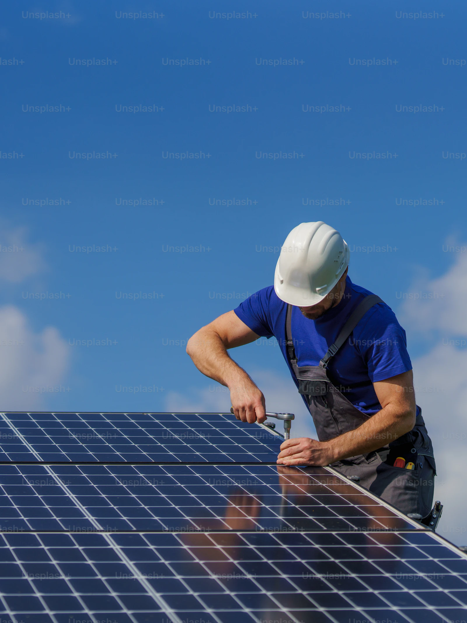 Installers at work on a sloped residential roof with solar panels