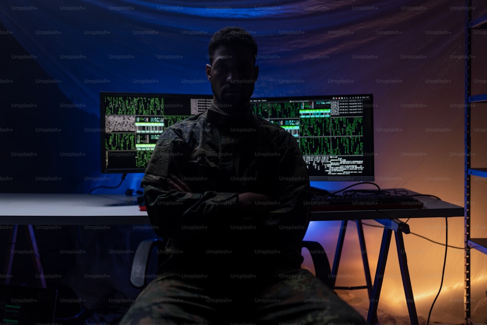 Un hacker anónimo en unifrorm militar en la web oscura, concepto de guerra cibernética.