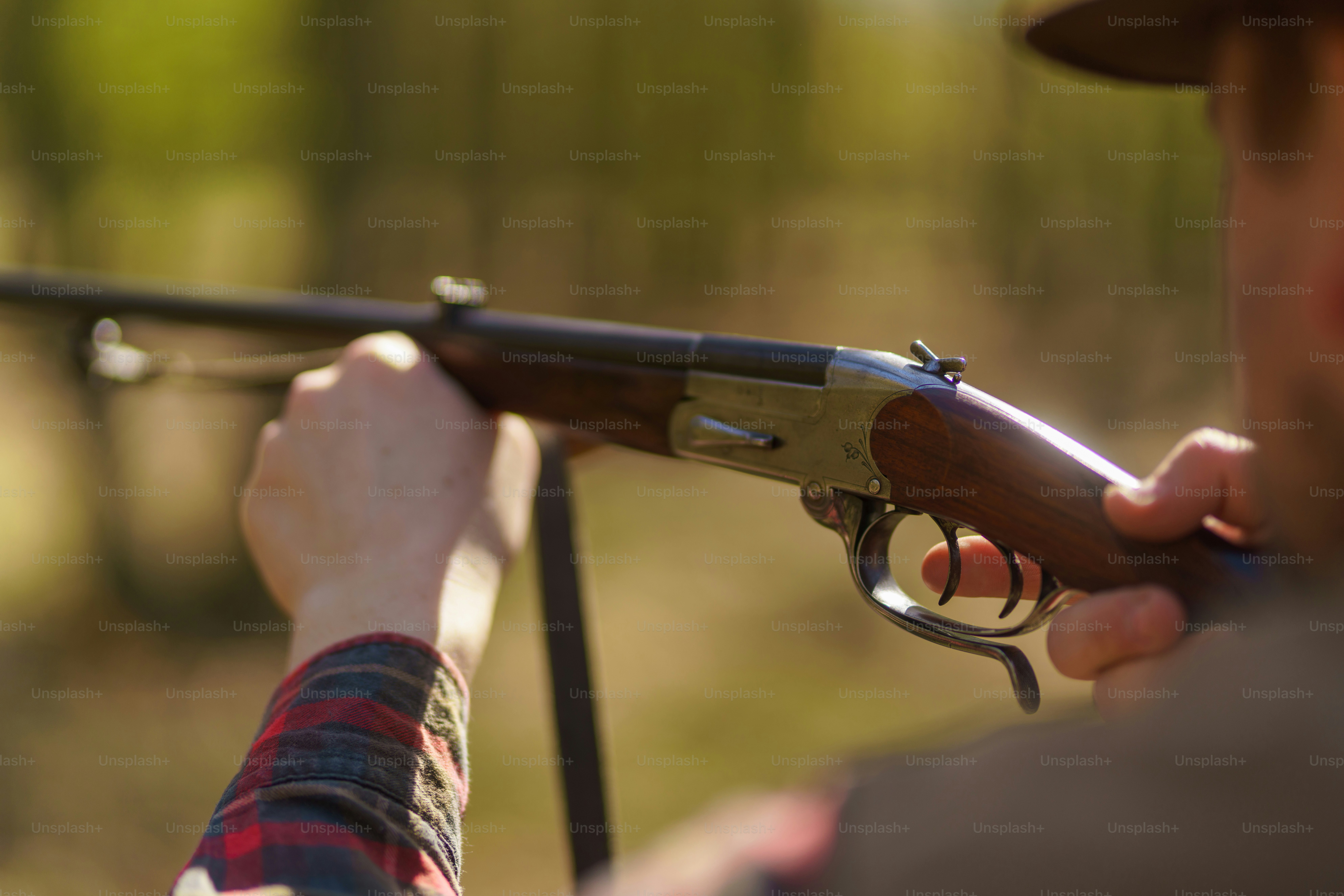 A hunter man aiming with rifle gun on prey in forest