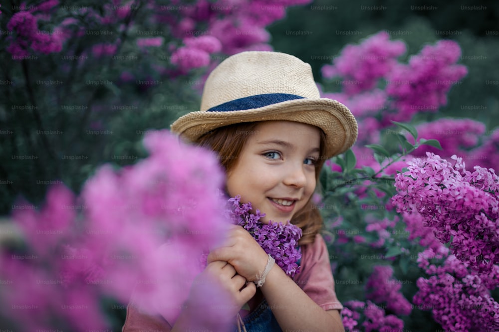 라일락 보라색 초원에 피는 자연에서 쾌활한 어린 소녀의 초상화.