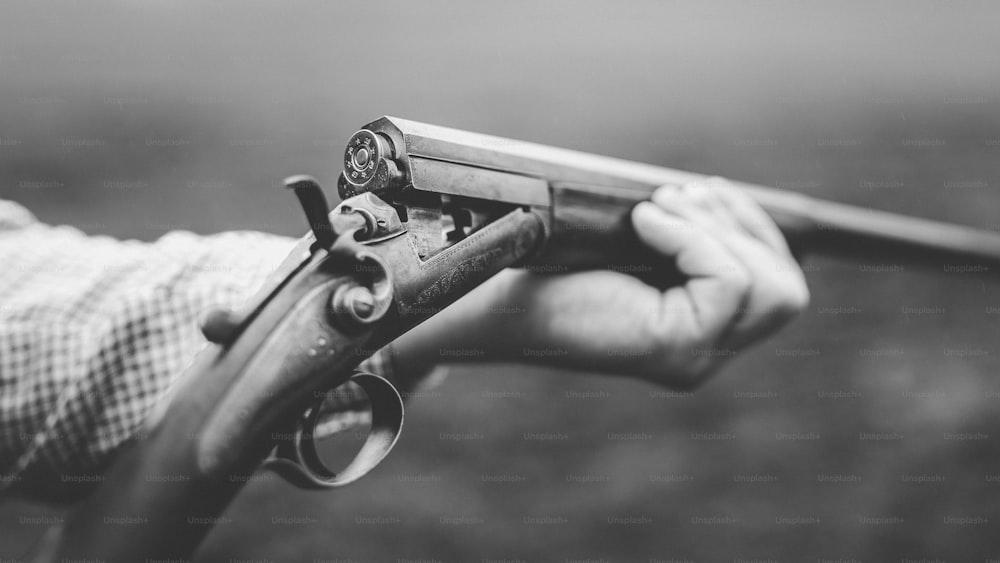 A close-up of hunter man charges the cartridge on rifle gun in forest.