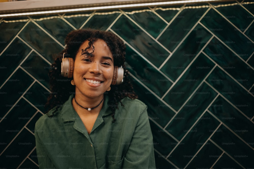 A young biracial woman wearing headphones and enjoying listening to music indoors.
