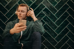 A young man with headphones enjoying listening to music indoors.