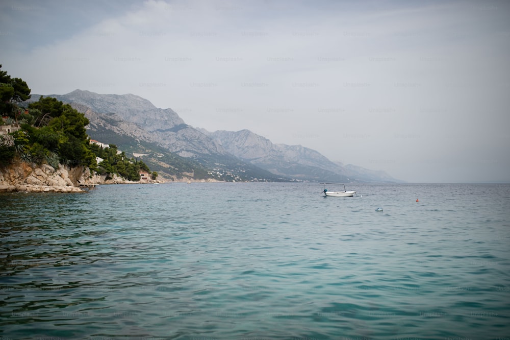 여름 화창한 날 크로아티아의 산 아래 아드리아 해 연안에있는 마을의 풍경