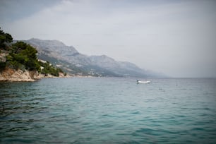 夏の晴れた日のクロアチアの山の下のアドリア海沿岸の町の風景