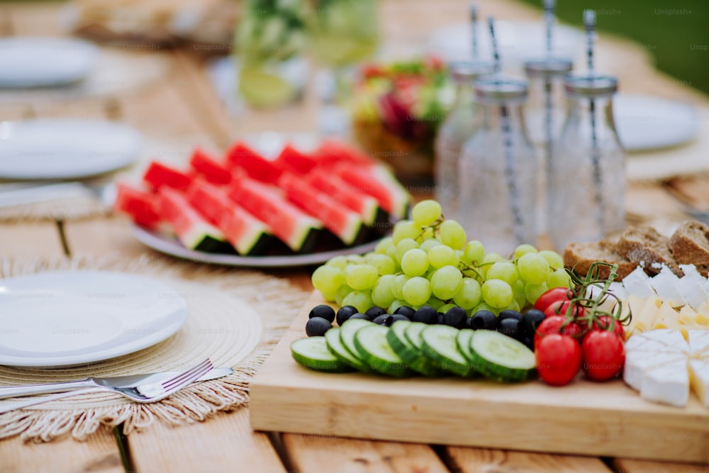 Un tavolo da pranzo apparecchiato per cenare in terrazza in estate, concetto di festa in giardino.