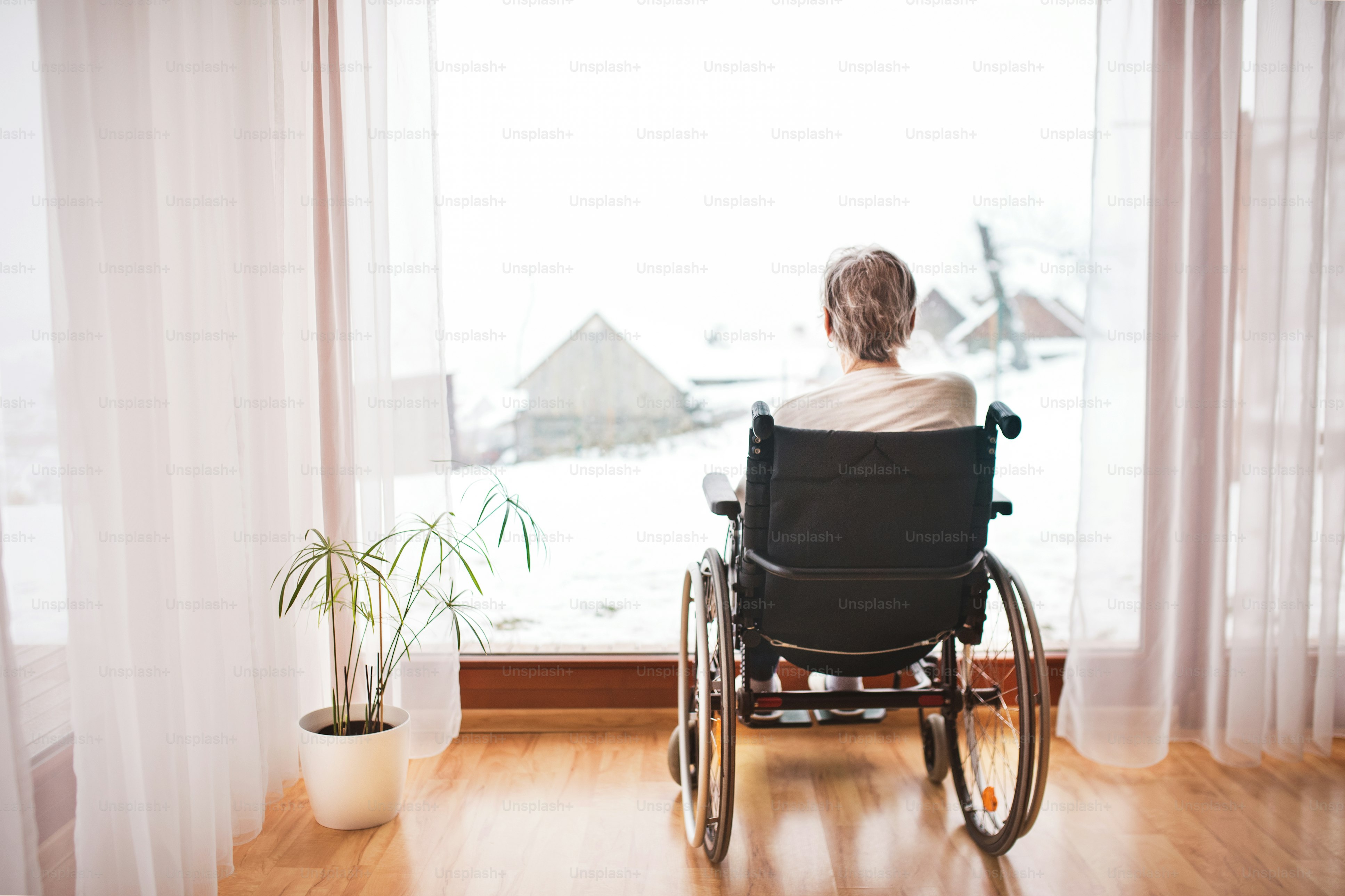 elderly person in wheelchair staring out the window