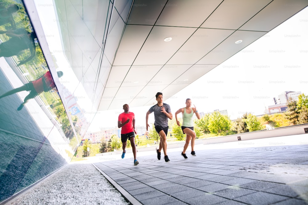 Beautiful young people in the city running together.