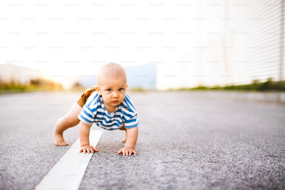 道路を外を這うかわいい男の子。クローズアップ。