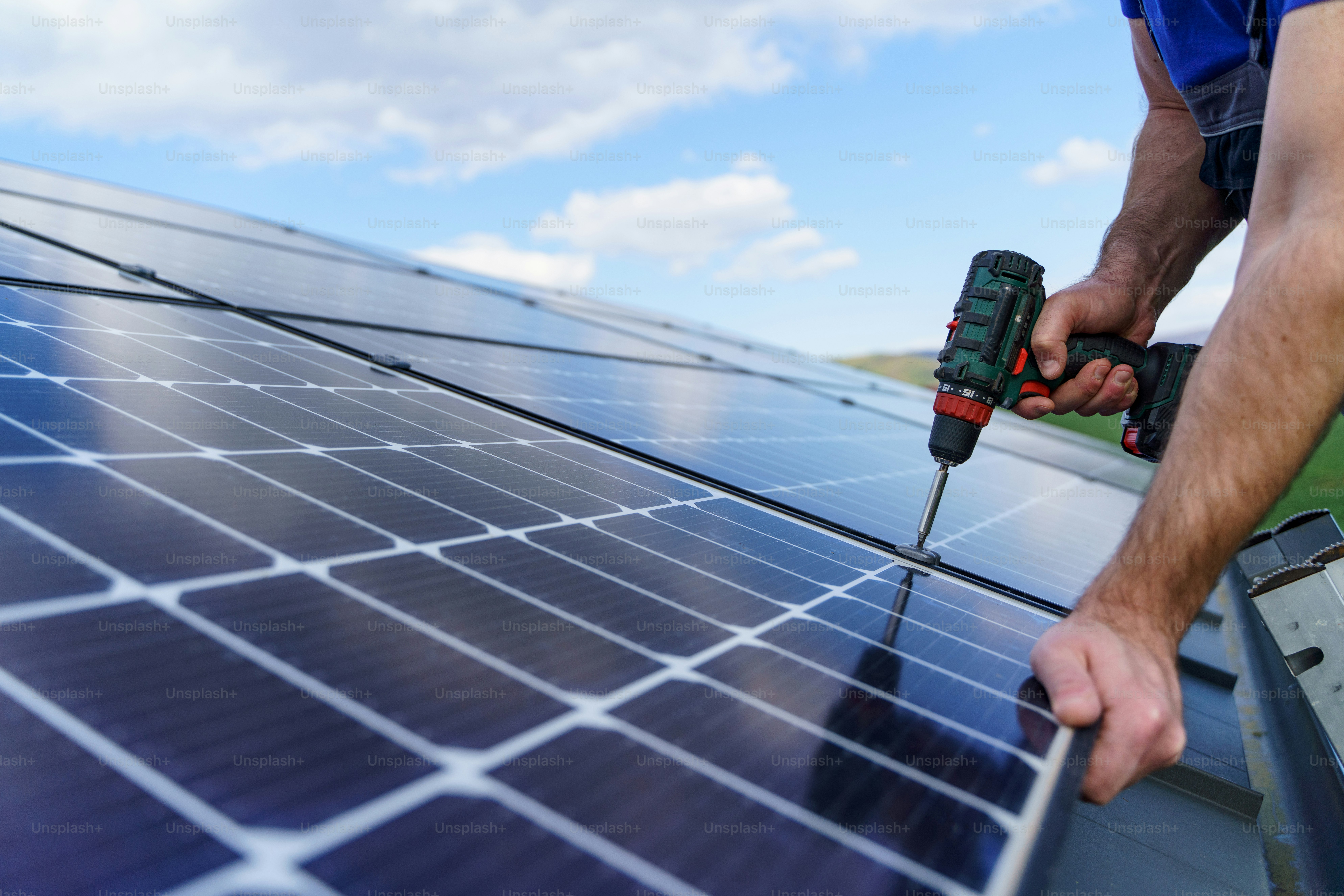 A man worker installing solar photovoltaic panels on roof, alternative ...