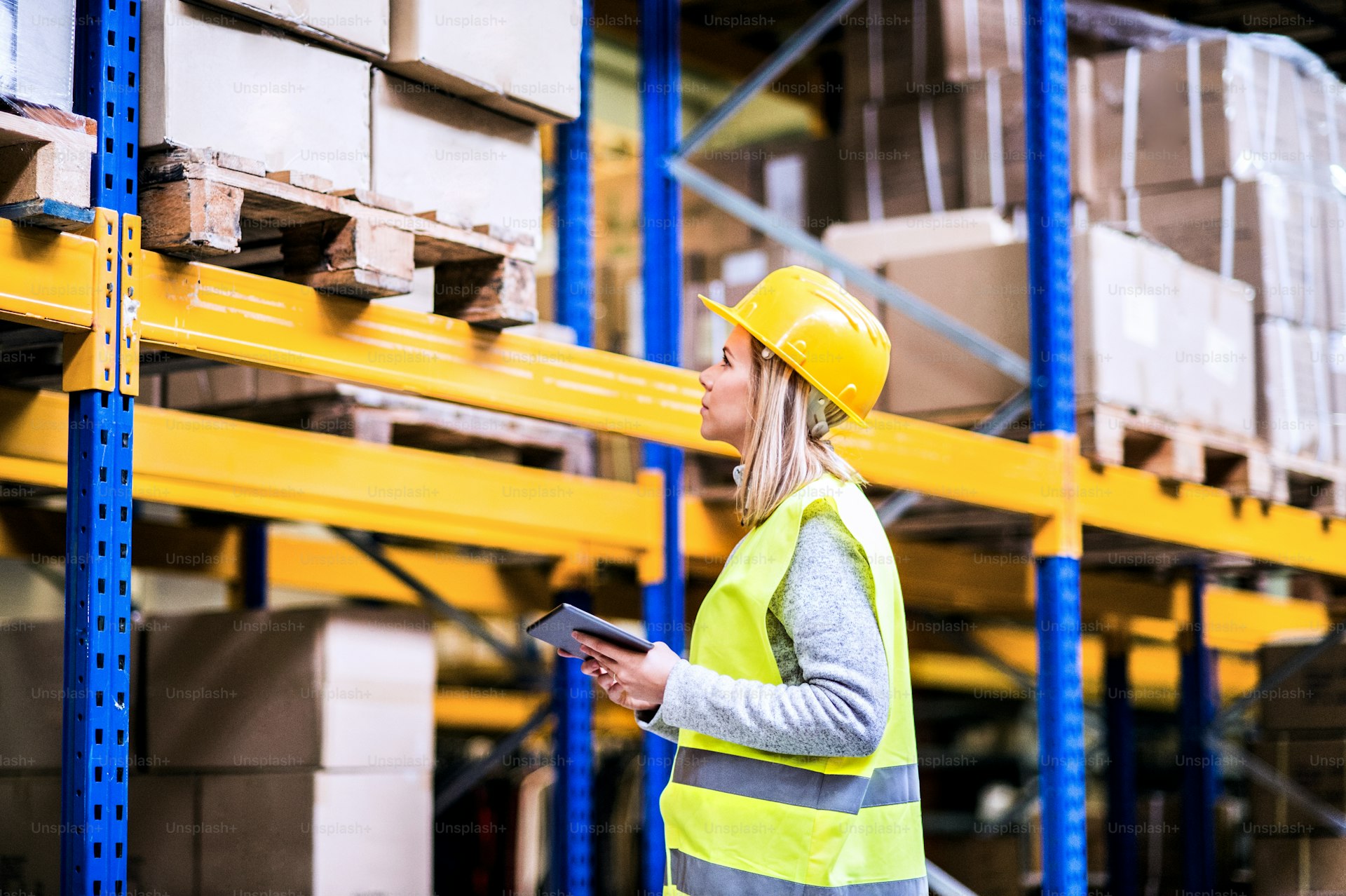 Warehouse supervisor with a tablet reviewing inventory and stock levels
