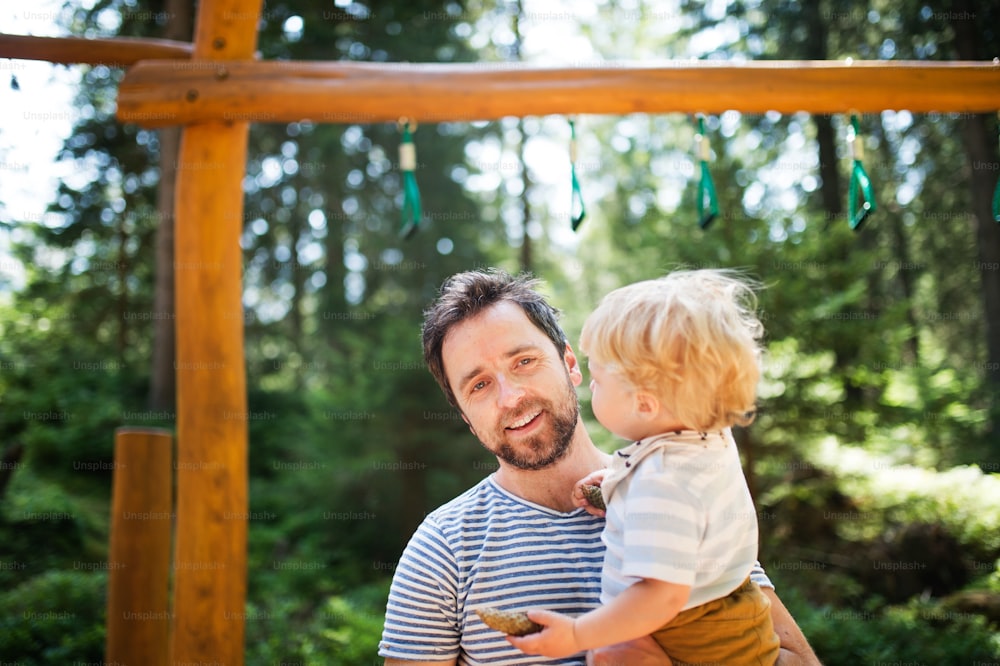 Young father with cute little boy on the playground.