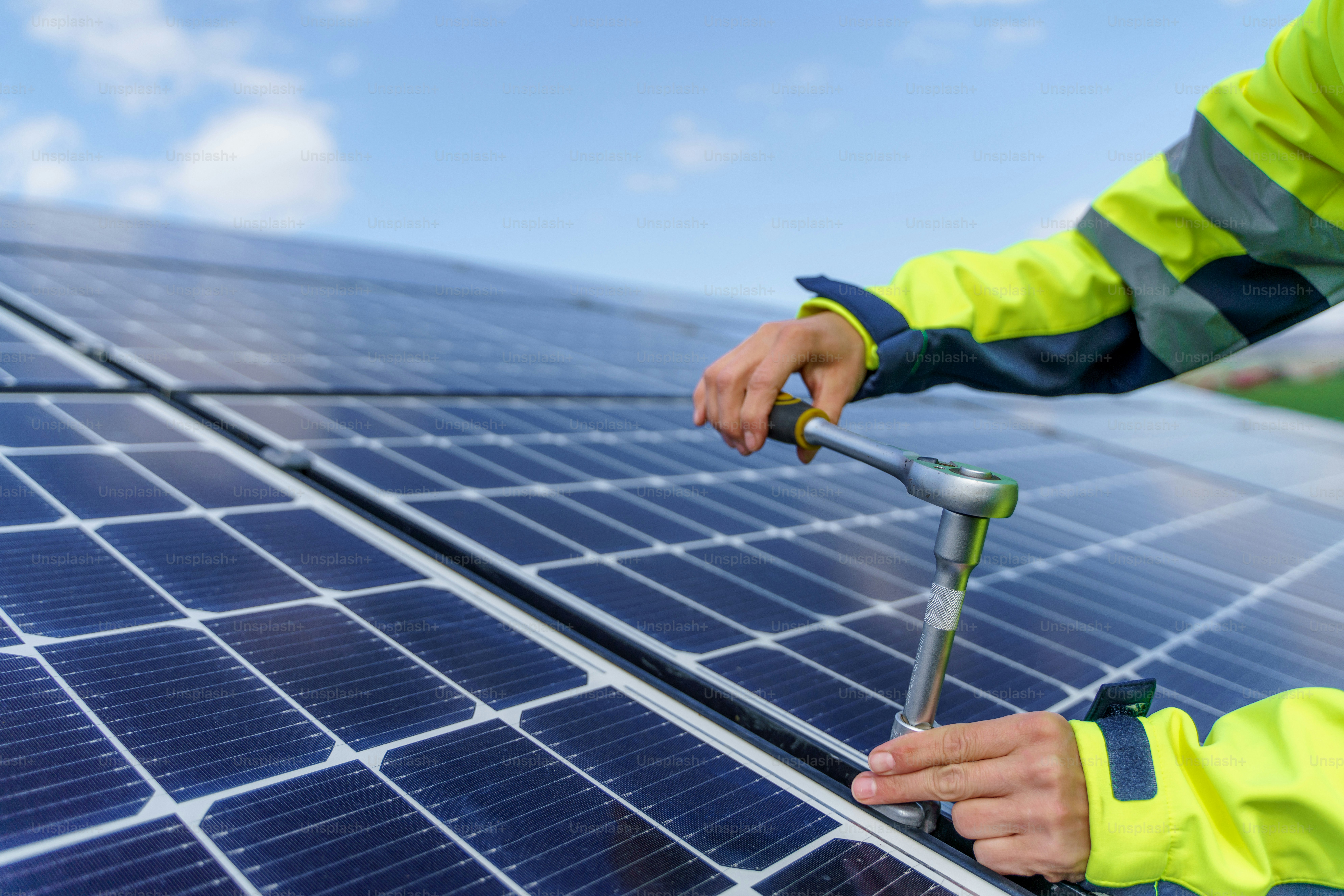 Eine Nahaufnahme einer Ingenieurin, die Photovoltaikmodule auf dem Dach installiert, alternatives Energiekonzept.