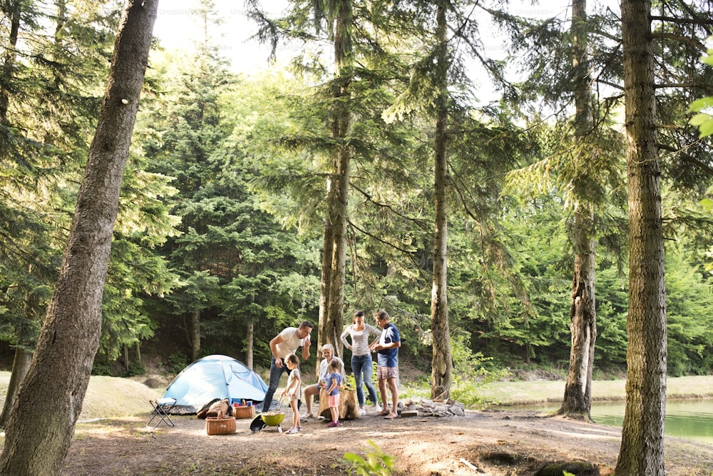 숲에서 캠핑 휴가를 즐기는 아름다운 가족.