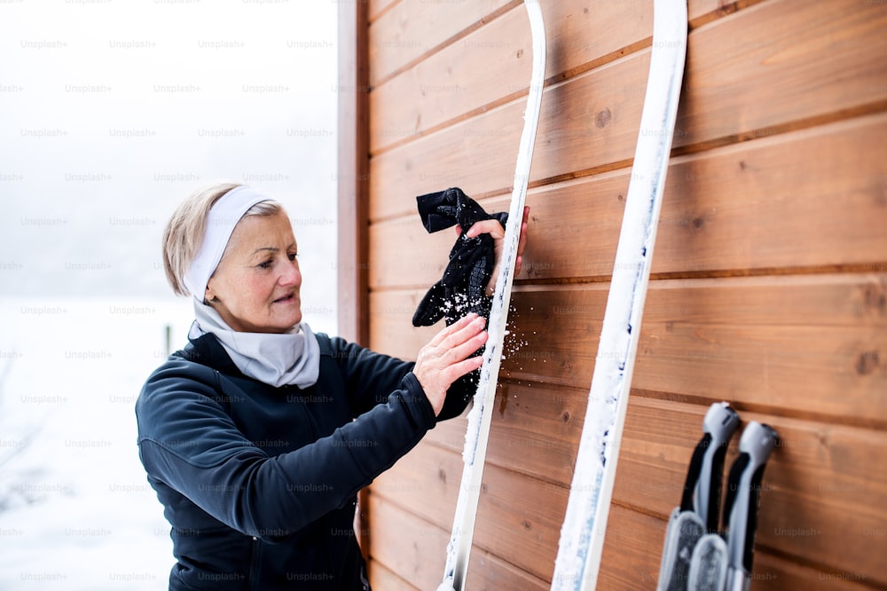 Aktive Seniorin bereitet sich auf das Skifahren vor. Winterzeit.