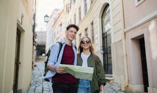 Junge Paare Reisende zu Fuß mit Karte in der Stadt im Urlaub, Sightseeing.