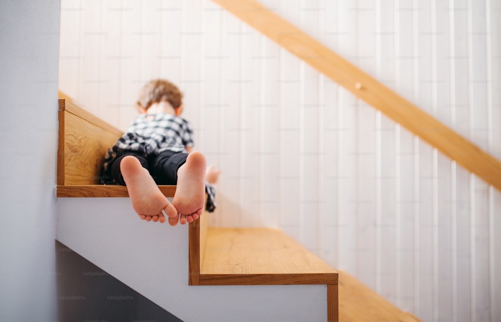 A rear view of small girl lying down on staircase. A copy space.