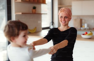 Une jeune femme jouant avec sa petite fille à la maison, riant.