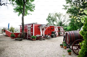 Countryside red and white farm building on summer day.