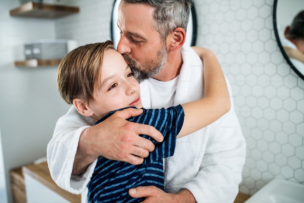 A mature father with small son in the bathroom in the morning, kissing.