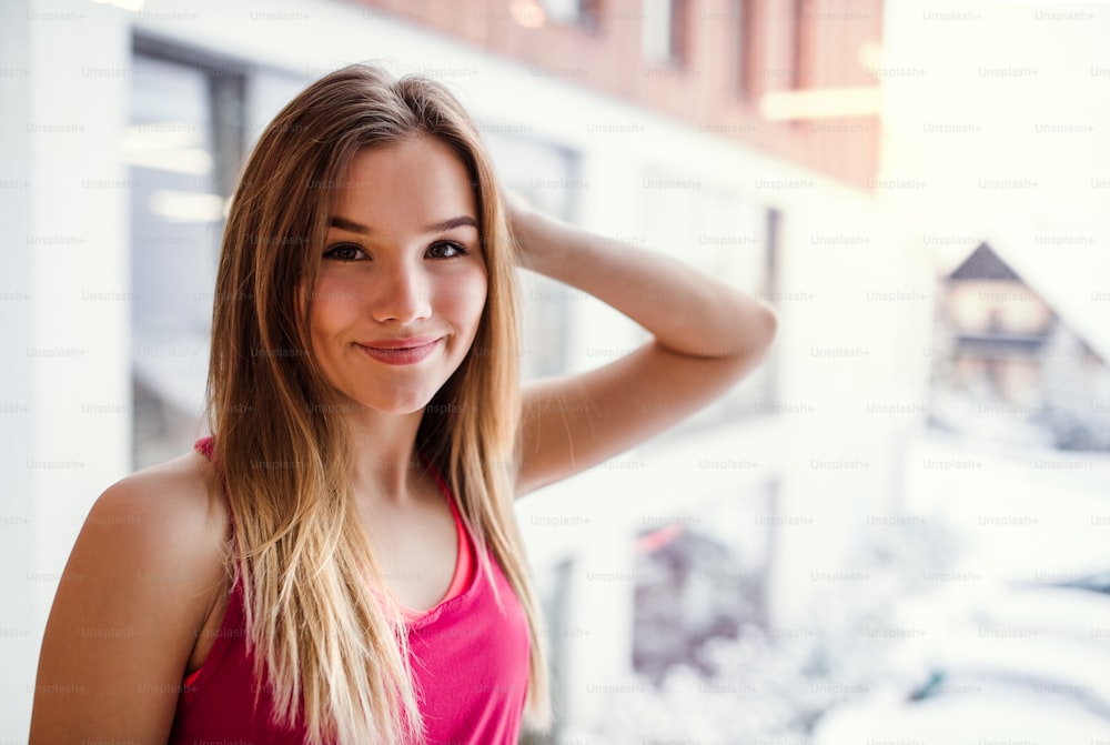 A portrait of beautiful young girl or woman in a gym. Copy space.
