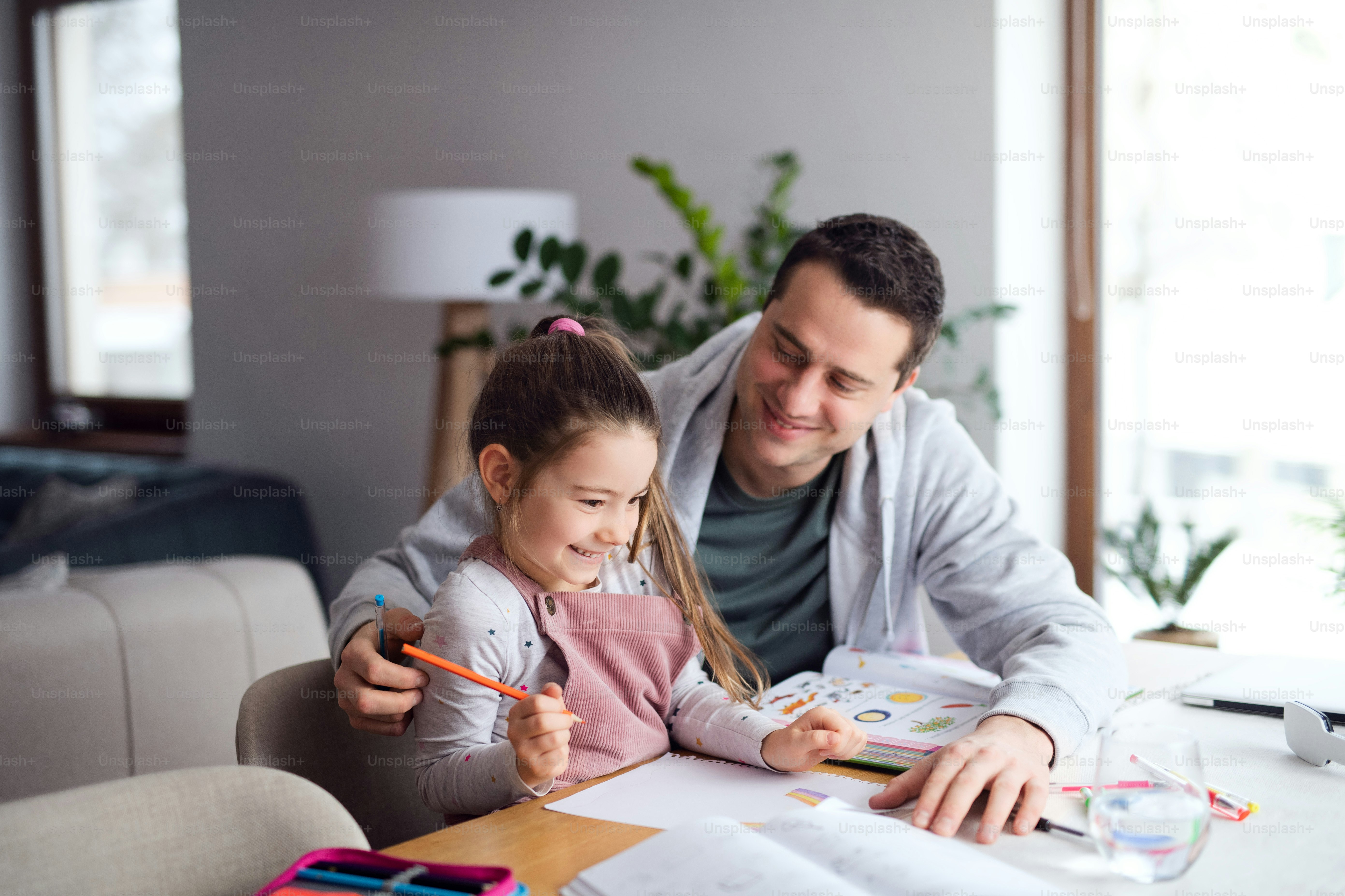 Foto Padre ayudando a la pequeña hija con los deberes en casa ...
