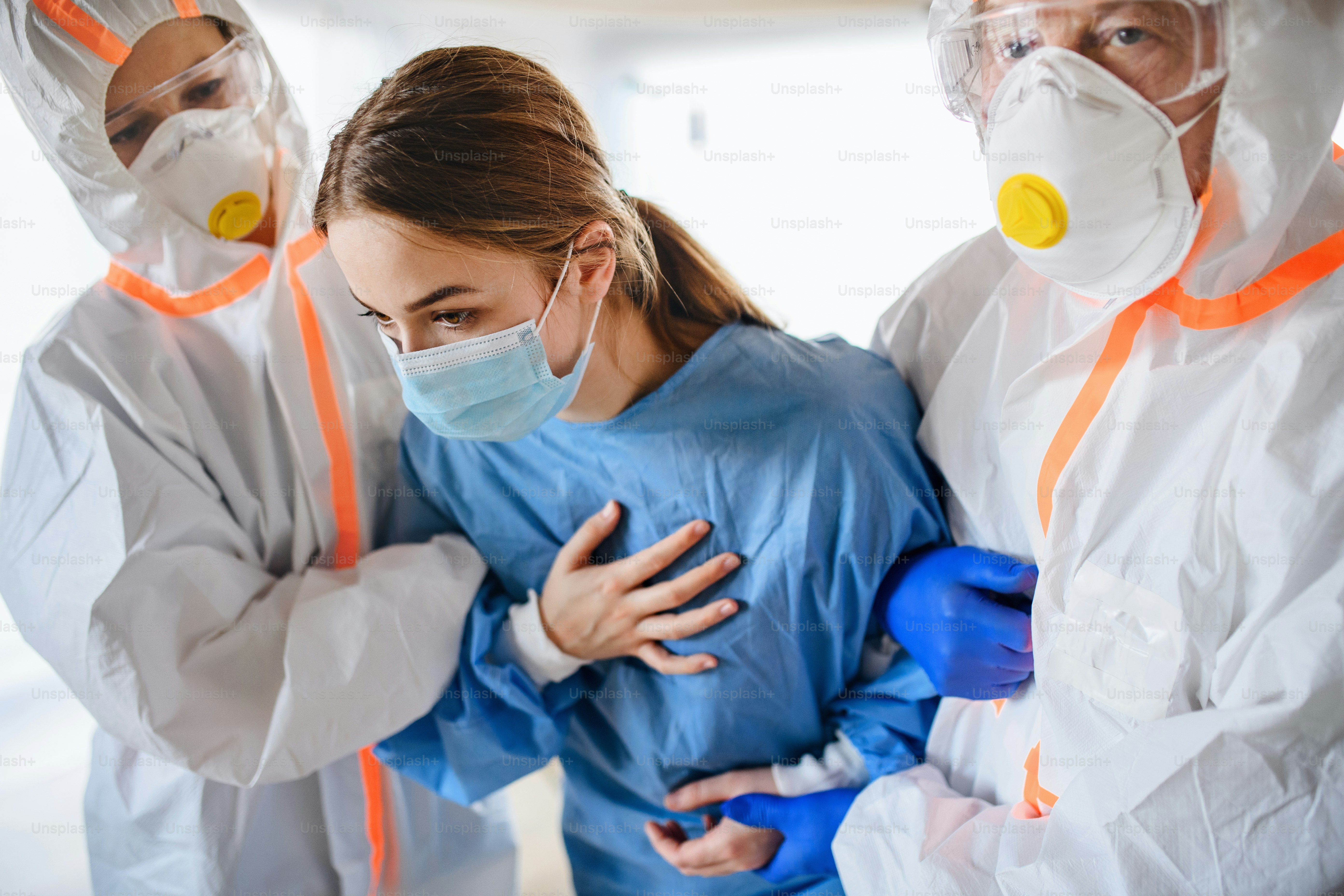 Doctors and infected patient walking in quarantine lying in bed in hospital, coronavirus concept.