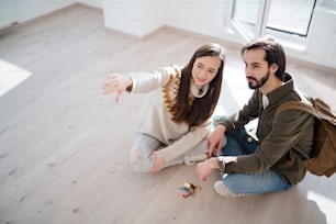 Top view of happy young couple with keys moving in new flat, new home and relocation concept.