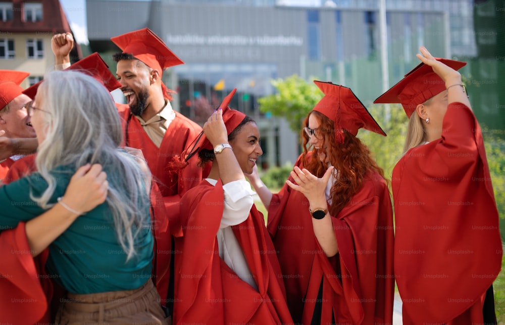 A group of cheerful university students celebrating outdoors, graduation concept.