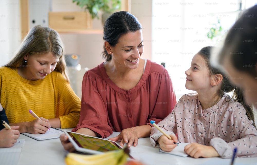 Gruppe von Homeschooling-Kindern mit Elternlehrer, die drinnen lernen, Coronavirus-Konzept.