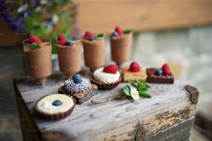 Selection of colorful and delicious cake desserts on a rusty wooden box.