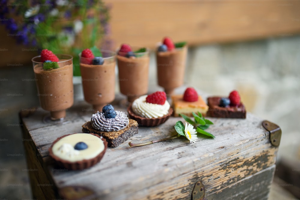 Selection of colorful and delicious cake desserts on a rusty wooden box.