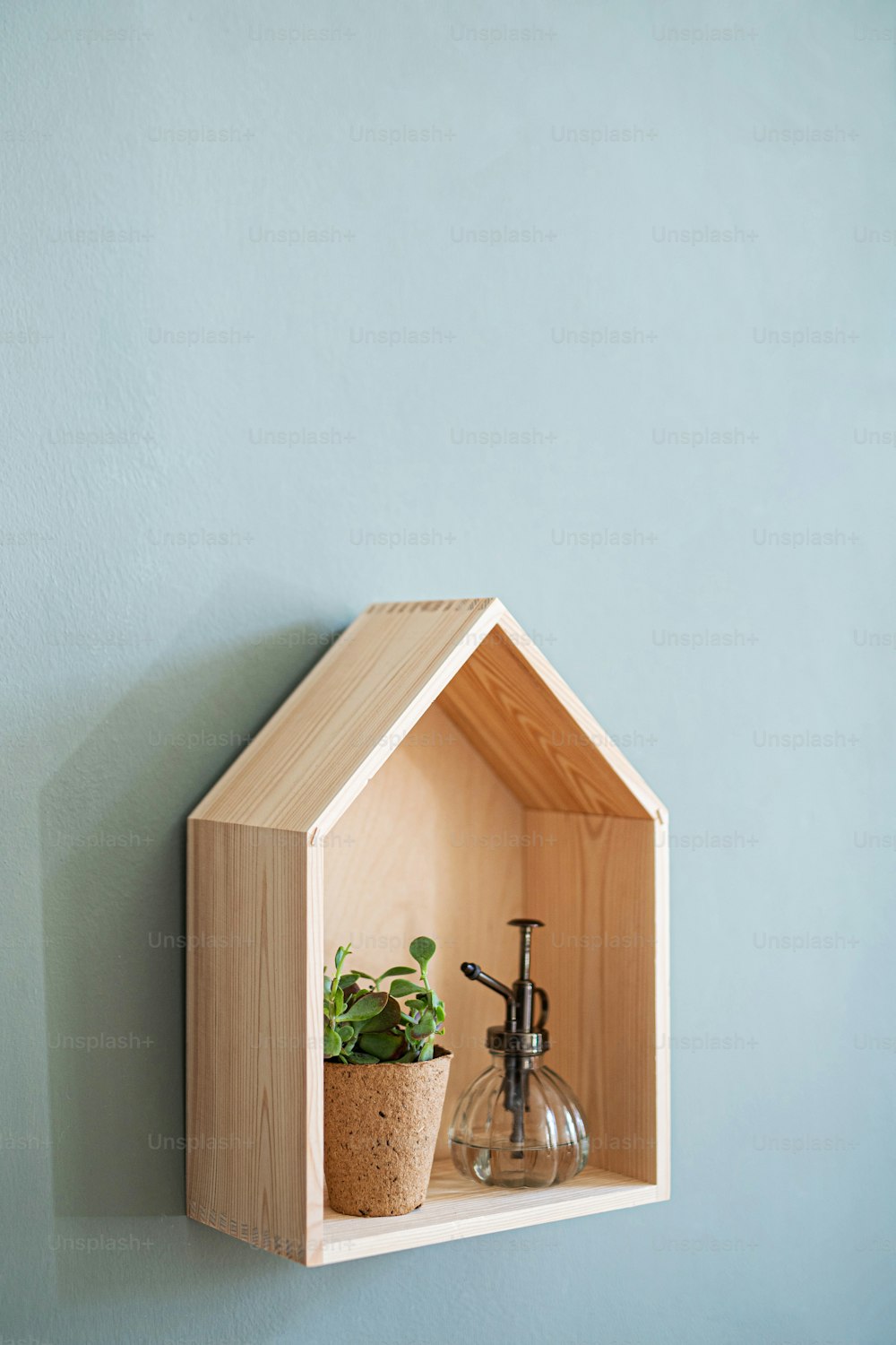 A wooden house shelf with decorations on the wall, natural decor concept.
