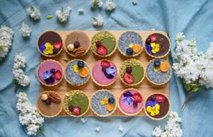 A top view of selection of colorful and delicious cake desserts in box on table.