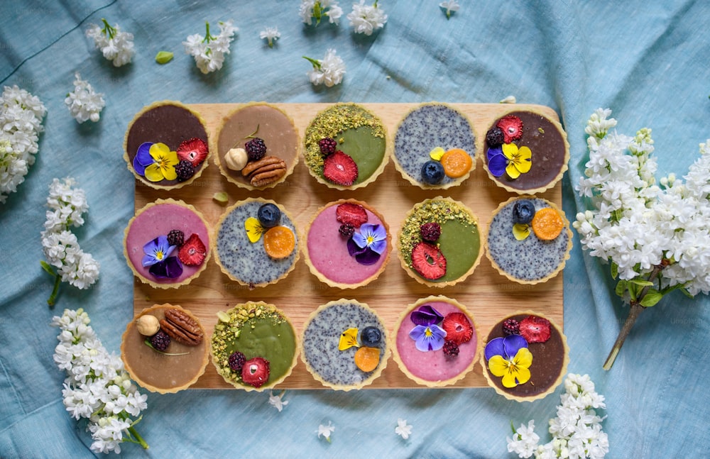 A top view of selection of colorful and delicious cake desserts in box on table.