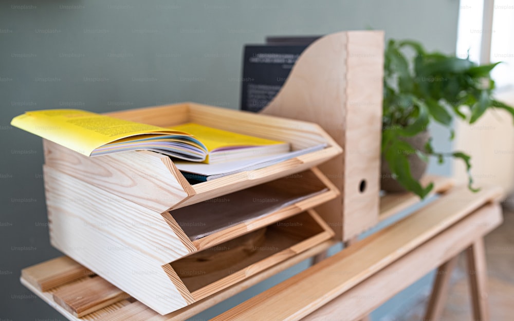 종이와 문서 나무 트레이 홀더와 정리 의자가 식물, 자연 장식 개념으로 책상 위에 있습니다.