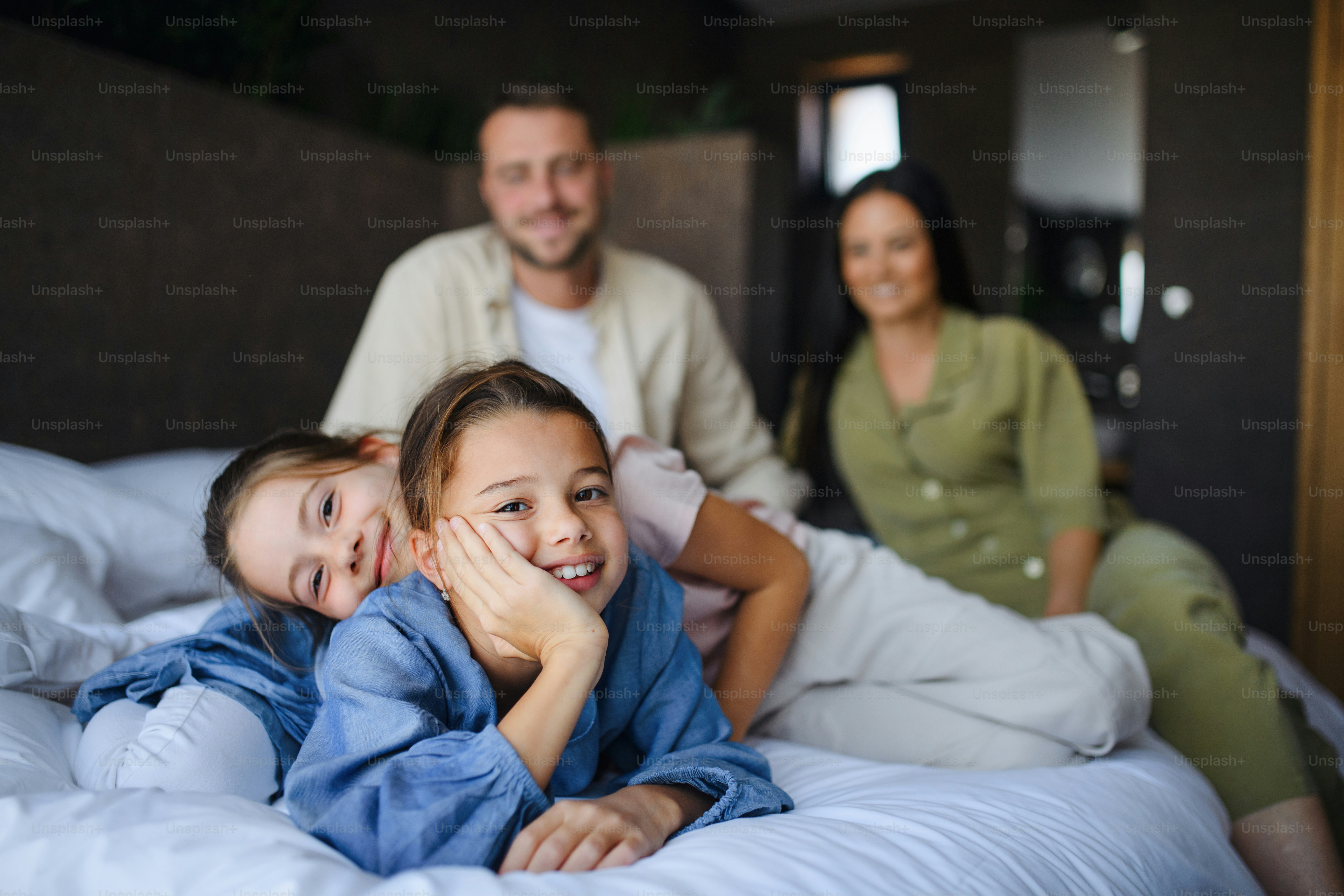 Foto Una familia joven feliz con dos niños acostados en la cama en el ...