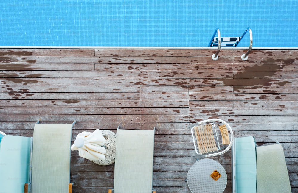 A top view of sunbathing deck and private swimming pool near beach, summer holiday concept. Copy space.