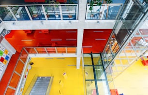 Vista de alto ângulo do interior amarelo de uma biblioteca moderna e espaçosa com computadores para o público.