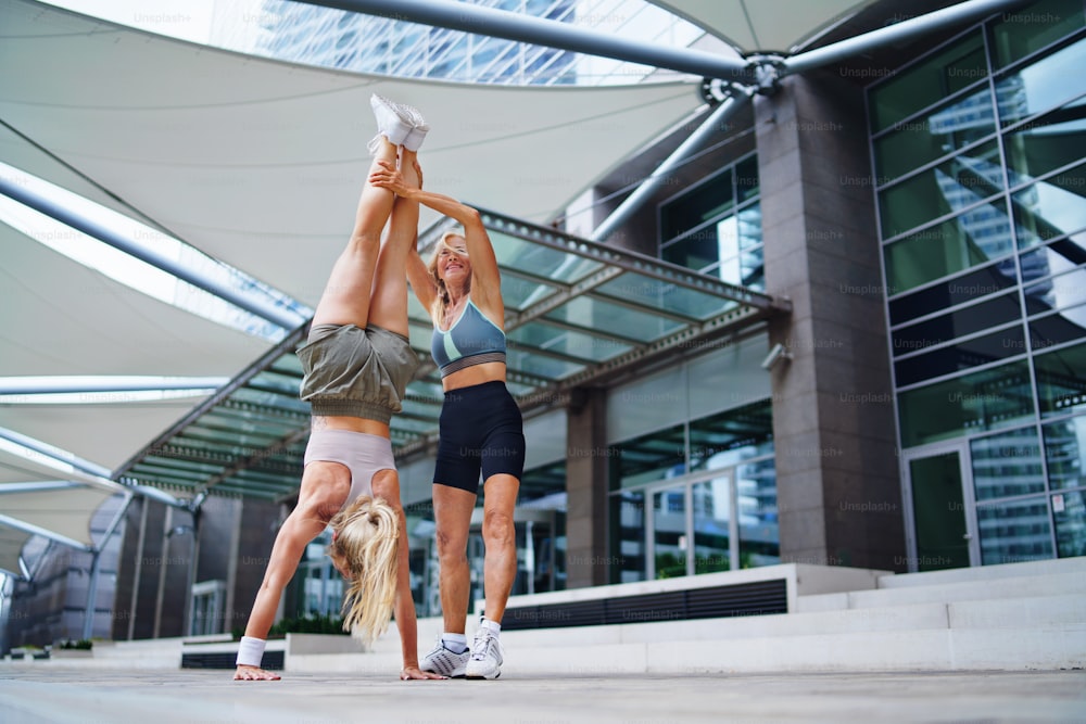 도시에서 야외에서 운동을 하는 두 명의 행복한 여성, 건강한 라이프스타일 개념.