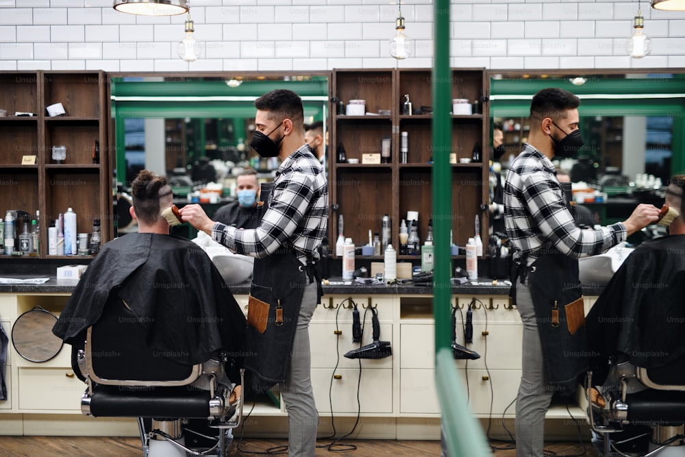 Client d’homme visitant un coiffeur et un coiffeur dans un salon de coiffure, coronavirus et nouveau concept de normalité.